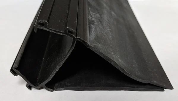 RV slide out coextruded plastic and rubber seal with layer of rubber bloom 